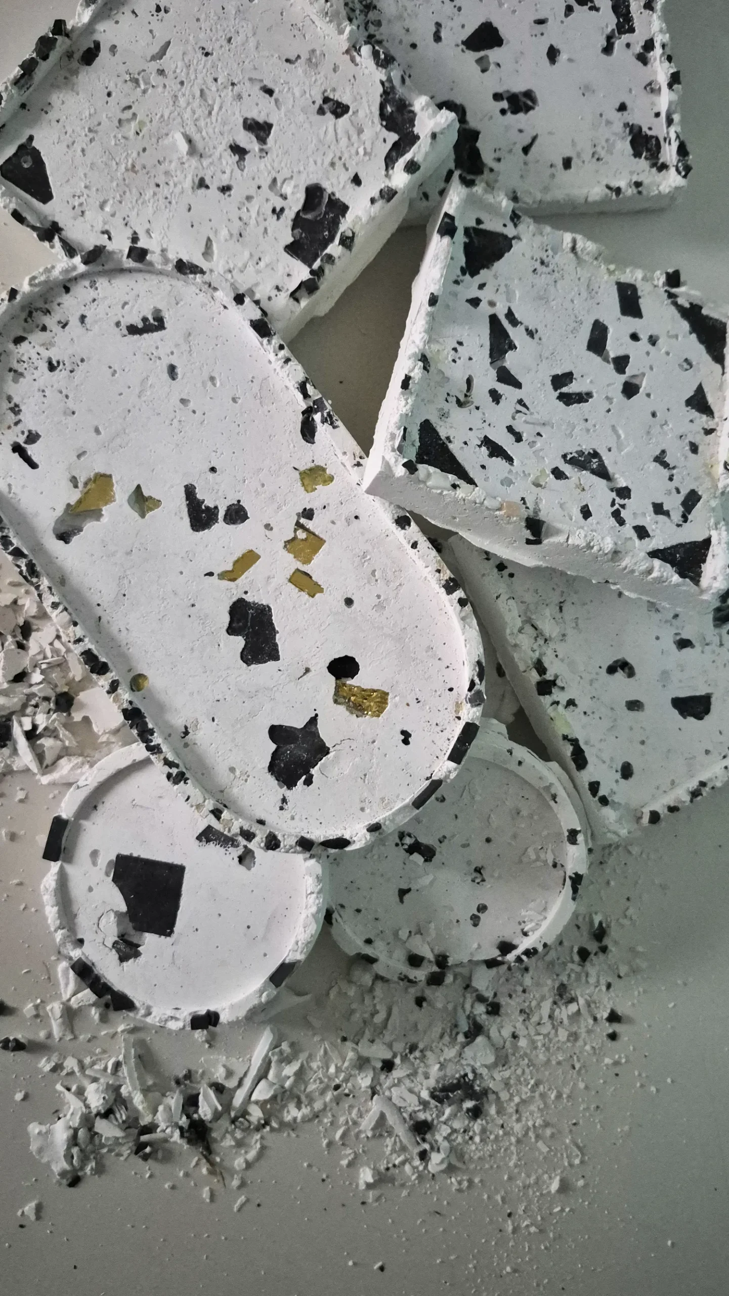 Prototypes de tesselles en terrasso recyclé · formes organiques arrondies · inclusions noires et dorées · R&D MATMOZ · La FABMOZ Nantes